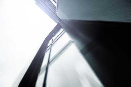 Wide angle abstract background view of steel light blue high rise commercial building skyscraper made of glass exterior. Business concept of successful industrial architecture and office center buildingの写真素材