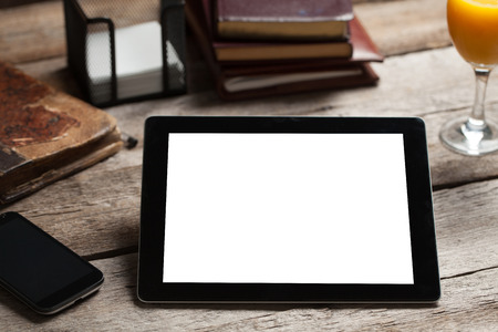 Black tablet on old wood tableの写真素材