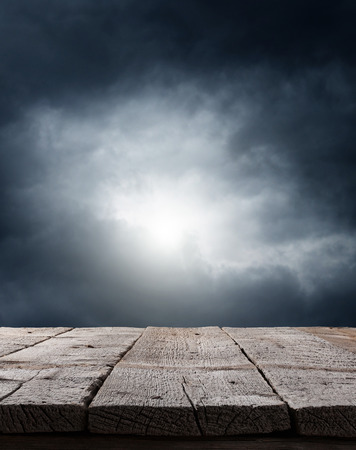 dramatic dark sky background with wooden floorの写真素材