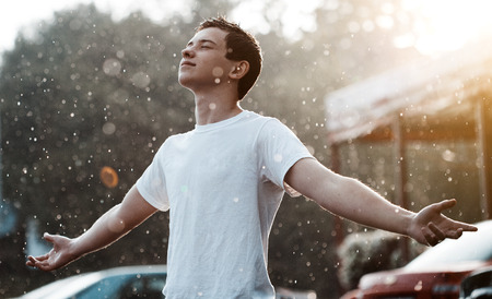 teenage boy under rain in the city teenage boy under rain in the city