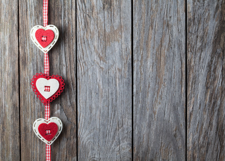 hearts hanging over old wood backgroundの写真素材