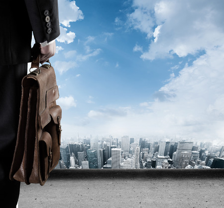 Businessman looking to the future from high point into the cityの写真素材