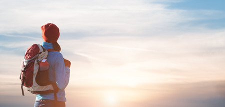 Hiker girl with backpack  looking to the horizon  sunsetの写真素材