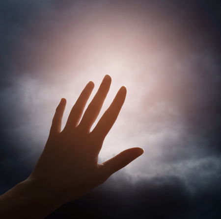 Hand reaching for the cloud in the skyの写真素材