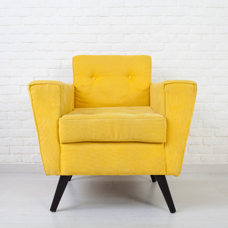 White wall texture with a retro yellow armchairの写真素材