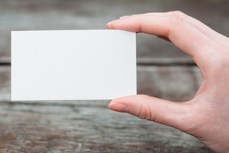 Hand holding a blank business or visit cardの写真素材