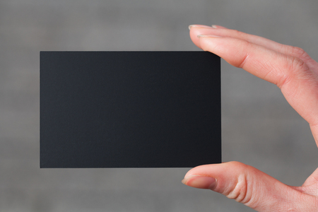 Hand holding a black business or visit cardの写真素材