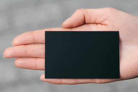 Hand holding a black business or visit cardの写真素材