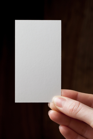 Hand holding a blank business or visit cardの写真素材
