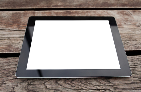 tablet pc computer gadget with isolated screen on a wooden backgroundの写真素材