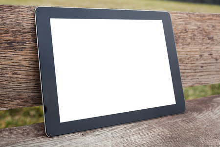 tablet pc computer gadget with isolated screen on a wooden backgroundの写真素材