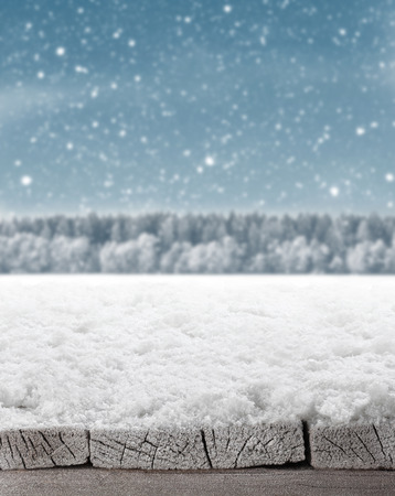 Blue Christmas background with trees and snow and wooden floorの写真素材