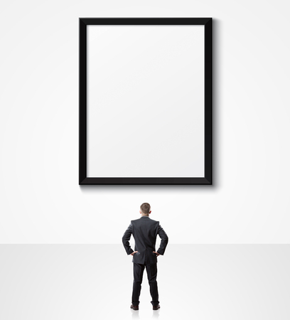 businessman looking up at empty posterの写真素材