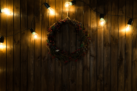 Light bulbs on dark wooden background with christmas decorの写真素材