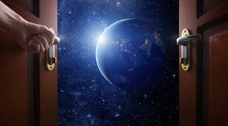 hand opens room door to galaxyの写真素材