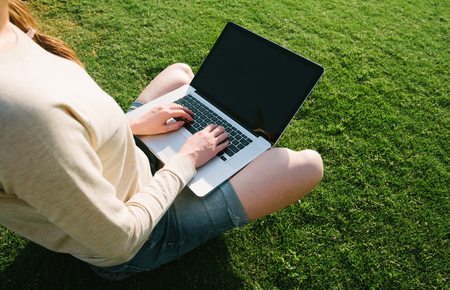 young girl with laptop in parkの写真素材