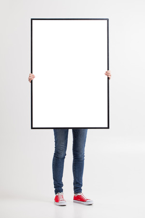 woman with blank poster on wall backgroundの写真素材