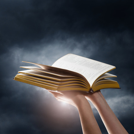 Opened book on a dark sky backgroundの写真素材