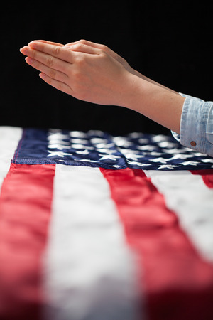 Hands praying over american flagの写真素材