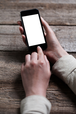 hand holding smart phone on wooden backgroundの写真素材