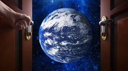 hand opens room door to galaxyの写真素材