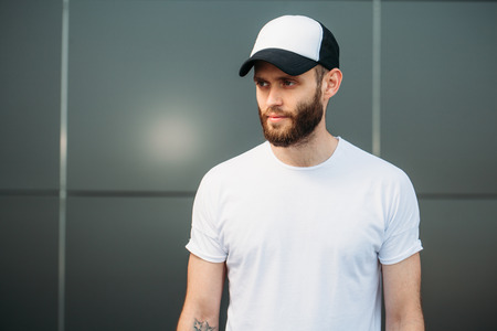 Hipster wearing white blank t-shirt and a baseball cap with space for your logoの写真素材
