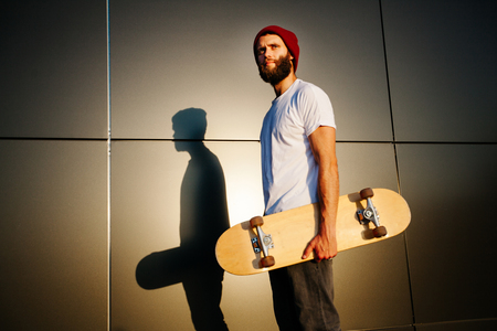 Portrait of a skaterboy hipster at duskの写真素材
