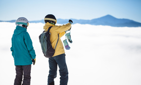 Two skiers taking photos over the highest mountain in ski resort in Europeの写真素材