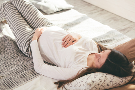 Pregnant woman in bedの写真素材