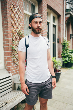 Hipster handsome male model with beard  wearing white blank  t-shirt with space for your logo or design in casual urban styleの写真素材