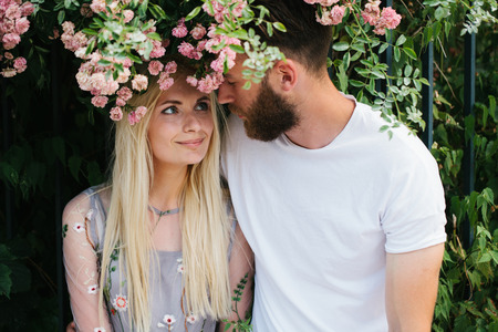 Dating couple kissing and hugging under rosesの写真素材