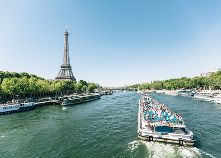 Paris, France - June 19, 2017: View of Eiffel tower, view from the river in the morning with a blue sky in a background and a boat moving along the Seine riverのeditorial素材