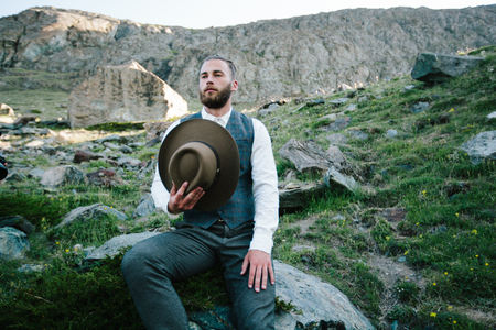 Hipster handsome male model portrait with beard wearing trendy clothes in the mountainsの写真素材