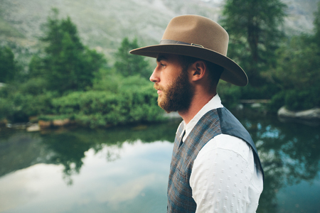 Hipster handsome male model portrait with beard wearing trendy clothes in the mountainsの写真素材