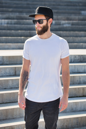 Hipster handsome male model with beard  wearing white blank  t-shirt with space for your logoの写真素材