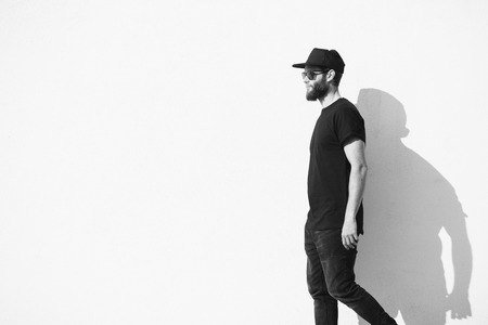 Hipster man walking along a wall wearing black clothesの写真素材