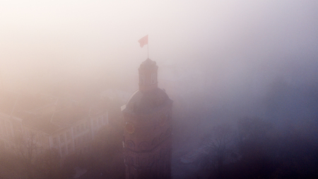 Europian city center of Vinnitsa covered in fog or mist with doves flying above. shot from aerial perspectiveの写真素材