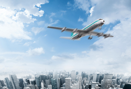Plane flying over the sky of a modern cityの写真素材