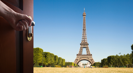 Hand opens room door towards an Eiffel Tower in Paris, Franceの写真素材