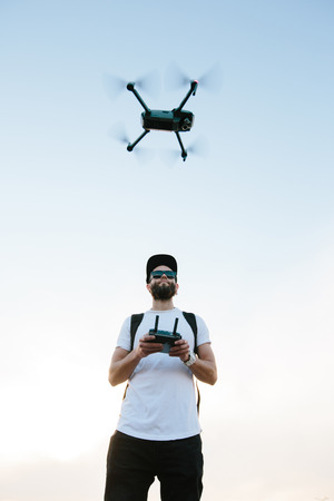 Man flying a drone copter by operating it の写真素材