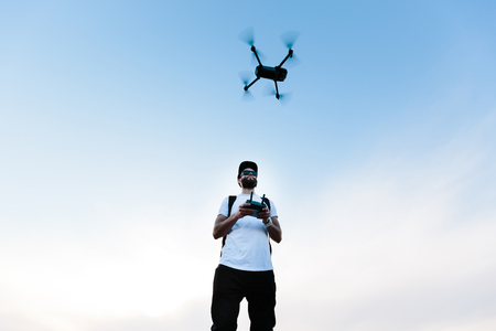 Man flying a drone copter by operating it の写真素材