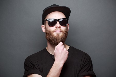 Hipster handsome male model with beard wearing black blank t-shirt with space for your logo or...