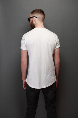 Hipster handsome male model with beard wearing white blank t-shirt with space for your designの写真素材