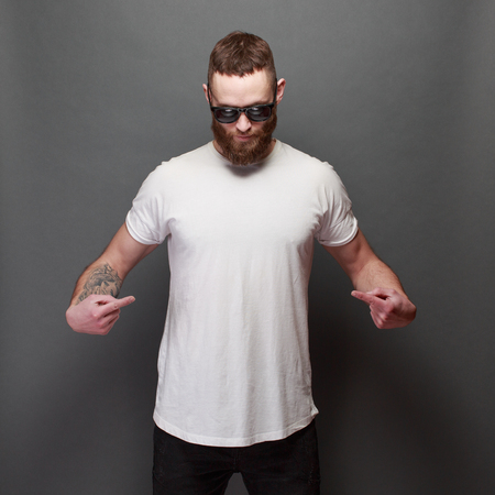 Hipster handsome male model with beard wearing white blank t-shirt with space for your designの写真素材