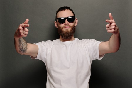 Hipster handsome male model with beard wearing white blank t-shirt and a baseball cap with spaceの写真素材