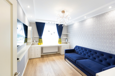 Modern living room interior design with blue sofa and a big windowの写真素材