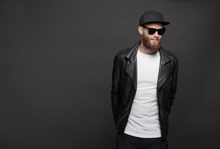 Hipster handsome male model with beard wearing white blank t-shirt and a baseball cap with space for...