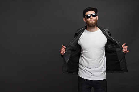 Hipster handsome male model with beard wearing white blank t-shirt and a baseball cap with space for your logo or design in casual urban styleの写真素材