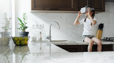 Kid girl using virtual reality glasses at homeの写真素材