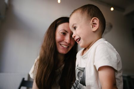 Mother and a baby son hugging and smilingの写真素材